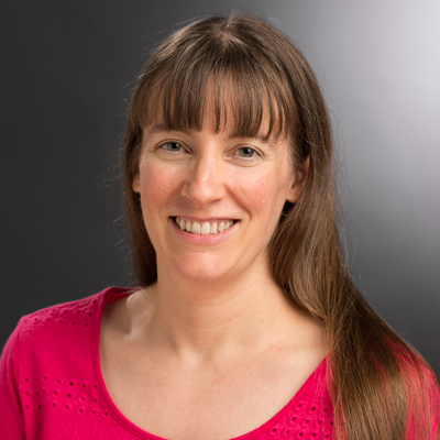 Headshot of Elizabeth Cherry in a red shirt with a grey background.