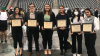 Six students pose with framed certificates for the best overall project in public policy award.